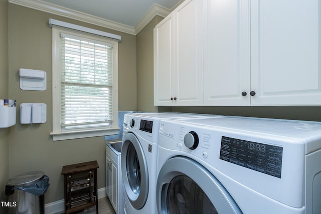 laundry area featuring washing machine and clothes dryer, cabinet space, crown molding, and baseboards