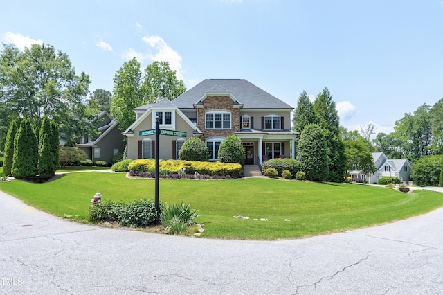 craftsman-style home with a front yard and stone siding