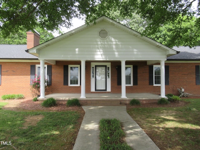 819 Patterson Grove Rd, Ramseur, NC 27316 - view of front facade featuring a porch, brick siding, and a chimney
