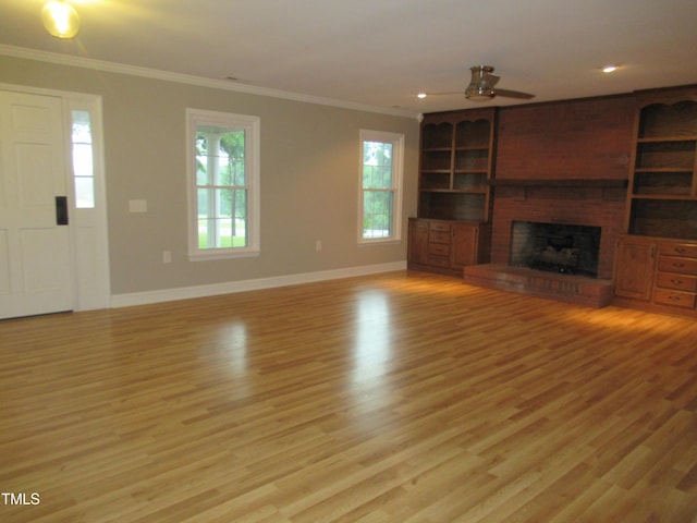 819 Patterson Grove Rd, Ramseur, NC 27316 - unfurnished living room featuring crown molding, baseboards, light wood finished floors, a ceiling fan, and a fireplace
