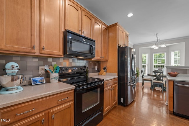 2012 Sterling Hill Dr, Fuquay Varina, NC 27526 - kitchen with black appliances, light countertops, tasteful backsplash, crown molding, and light wood-type flooring