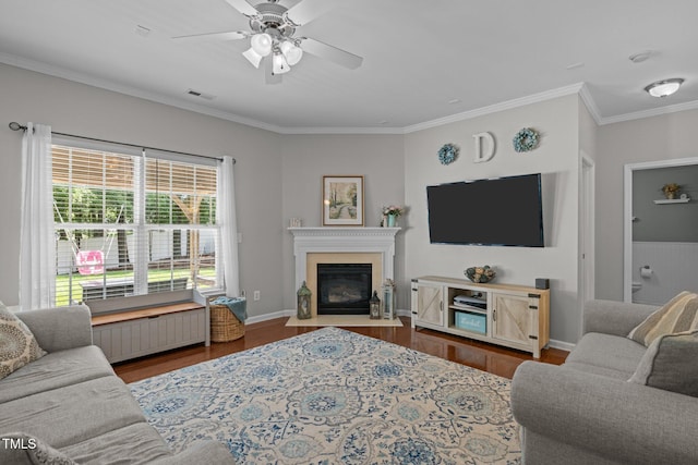 2012 Sterling Hill Dr, Fuquay Varina, NC 27526 - living room featuring crown molding, wood finished floors, a glass covered fireplace, ceiling fan, and baseboards