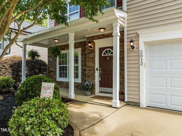 2012 Sterling Hill Dr, Fuquay Varina, NC 27526 - view of exterior entry with a garage, stone siding, and a porch