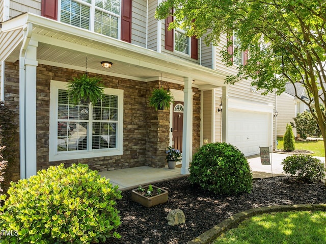 2012 Sterling Hill Dr, Fuquay Varina, NC 27526 - property entrance with a porch, a garage, stone siding, and concrete driveway