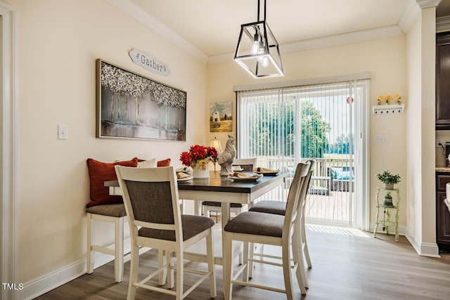 dining room with plenty of natural light, wood finished floors, baseboards, and ornamental molding