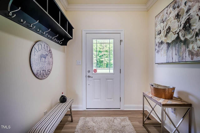 doorway with wood finished floors, ornamental molding, and baseboards
