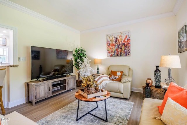 living area with ornamental molding, wood finished floors, and baseboards