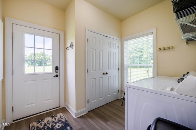 laundry area featuring separate washer and dryer, healthy amount of natural light, wood finished floors, and baseboards