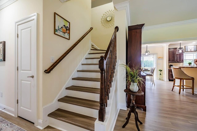 stairs featuring wood finished floors and baseboards