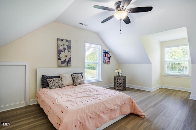 bedroom with multiple windows, wood finished floors, lofted ceiling, a ceiling fan, and baseboards