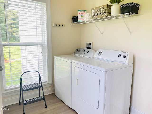 laundry room featuring washing machine and dryer and light wood-style floors