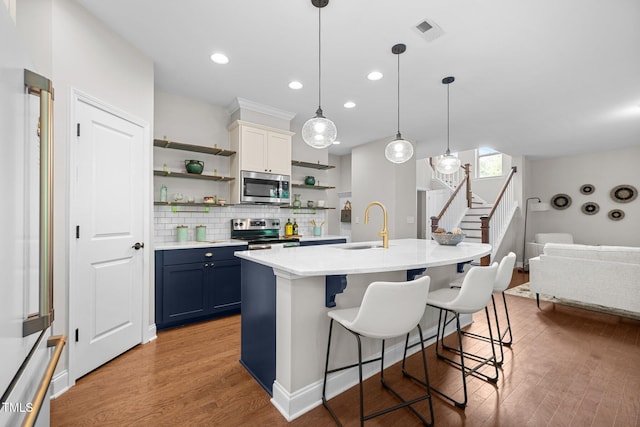 111 Chapel Run Way, Chapel Hill, NC 27517 - kitchen with stainless steel appliances, open shelves, a sink, blue cabinets, and light wood finished floors