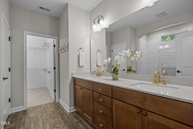 111 Chapel Run Way, Chapel Hill, NC 27517 - bathroom featuring double vanity, wood finished floors, a tile shower, and a walk in closet