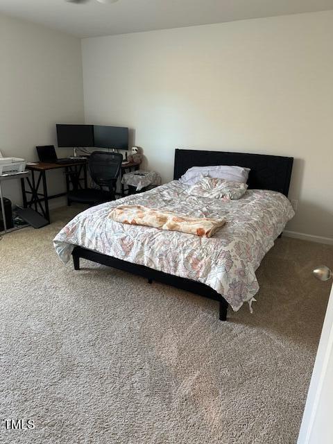 bedroom featuring carpet flooring, an office area, and baseboards