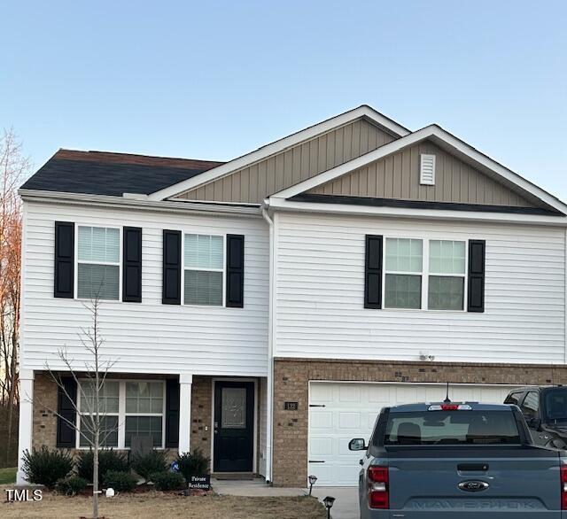 view of property featuring brick siding and an attached garage