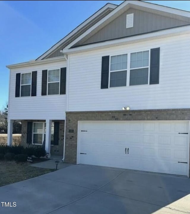 view of front of property featuring brick siding, driveway, and an attached garage