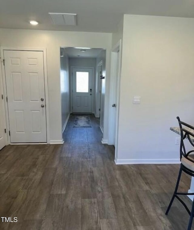 hallway with baseboards and dark wood-type flooring