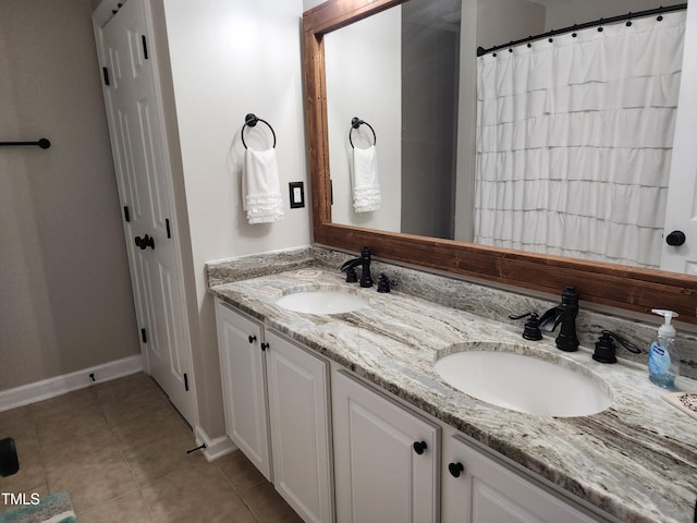 full bath featuring tile patterned flooring, double vanity, baseboards, and a shower with shower curtain