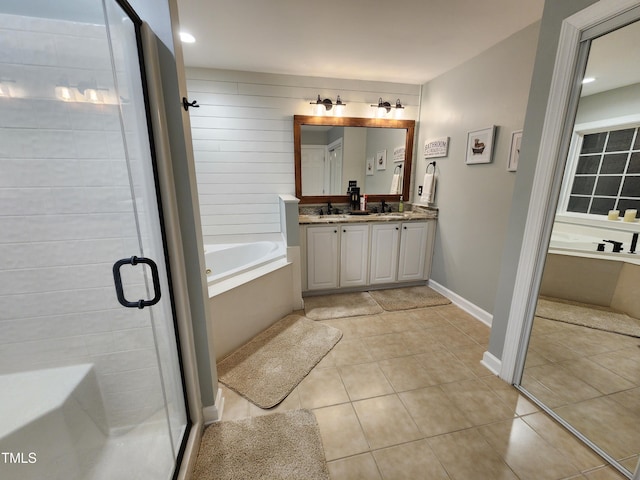 full bathroom featuring a shower stall, double vanity, a bath, and tile patterned floors