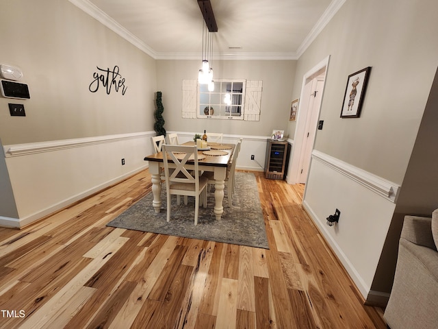 dining area with beverage cooler, light wood finished floors, and crown molding