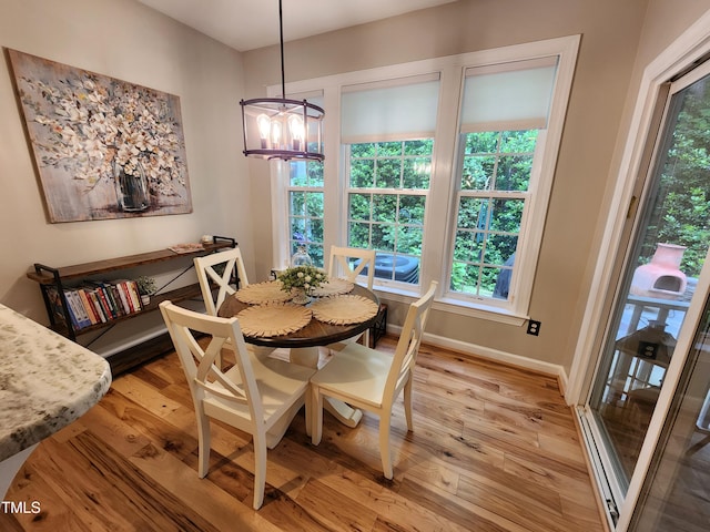 dining space featuring a chandelier, light wood-style floors, and plenty of natural light