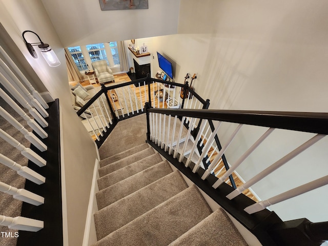 stairs with carpet and a high ceiling