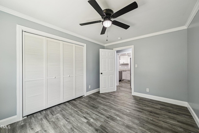 unfurnished bedroom with baseboards, ornamental molding, dark wood-style flooring, a closet, and a ceiling fan