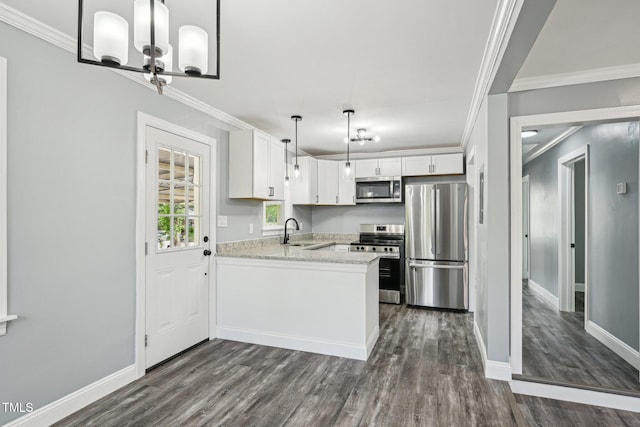 kitchen featuring appliances with stainless steel finishes, a sink, dark wood finished floors, a peninsula, and white cabinetry
