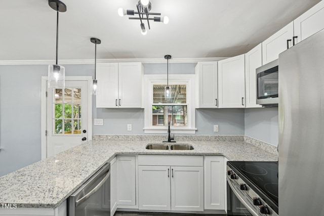 kitchen with stainless steel appliances, a sink, white cabinets, decorative light fixtures, and a peninsula