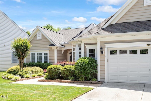view of front of property featuring roof with shingles, concrete driveway, and a garage