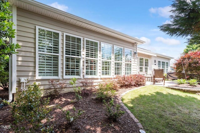 back of property featuring a patio and a yard