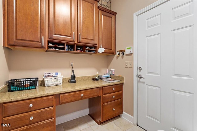 office featuring built in desk, baseboards, and light tile patterned floors