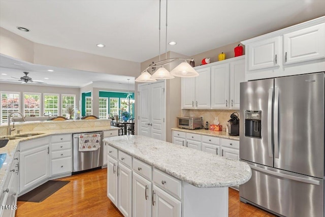 kitchen featuring stainless steel appliances, a sink, recessed lighting, decorative backsplash, and a ceiling fan