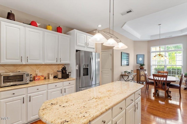 kitchen featuring stainless steel fridge, light wood finished floors, backsplash, white cabinetry, and recessed lighting