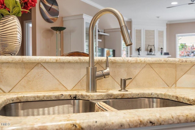 kitchen view of a sink, light stone countertops, recessed lighting, and tasteful backsplash