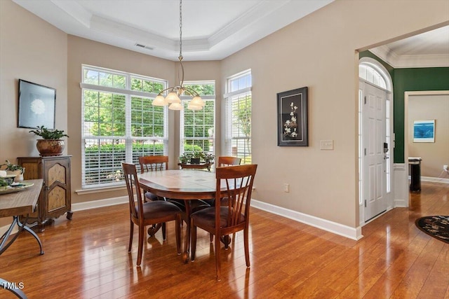 dining space featuring ornamental molding, light wood finished floors, a chandelier, and baseboards