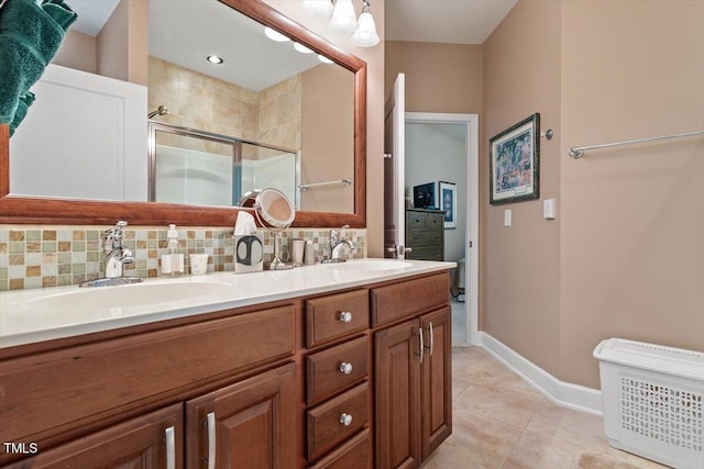 bathroom with a shower stall, decorative backsplash, double vanity, baseboards, and tile patterned floors