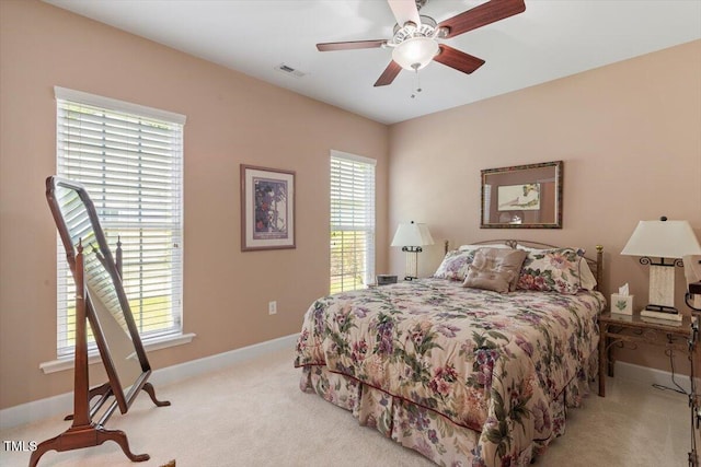 bedroom with light carpet, baseboards, and a ceiling fan
