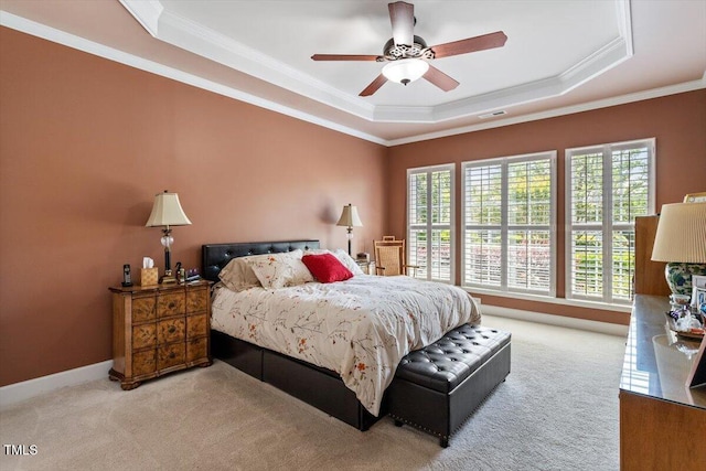 bedroom featuring a raised ceiling, carpet floors, crown molding, and ceiling fan