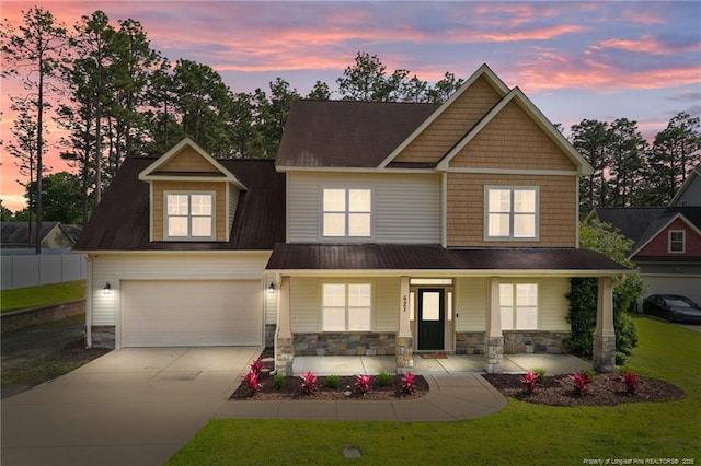 craftsman inspired home with concrete driveway, covered porch, stone siding, and a garage