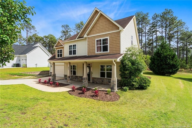 craftsman house with covered porch, driveway, a front lawn, stone siding, and an attached garage