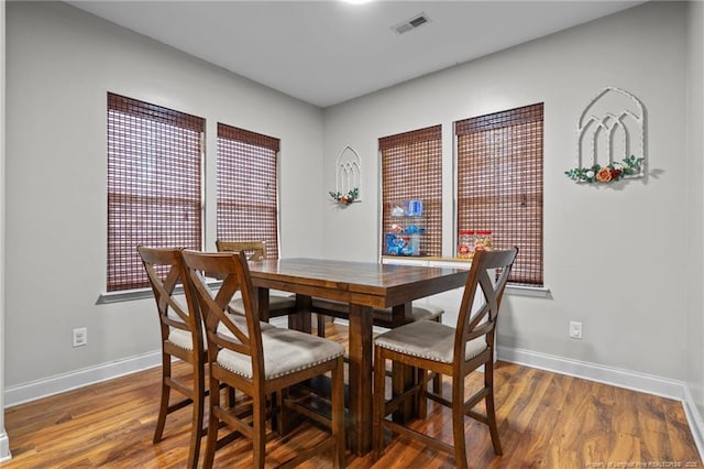 dining space featuring baseboards and wood finished floors