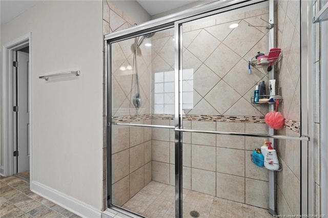 full bath with a shower stall and baseboards