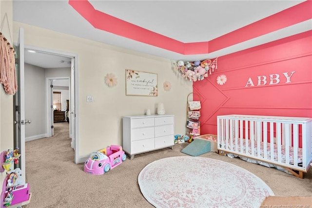 bedroom with carpet, a crib, and baseboards