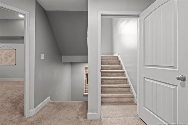 staircase featuring carpet, baseboards, and lofted ceiling