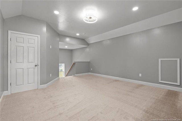 carpeted empty room featuring vaulted ceiling, baseboards, and recessed lighting