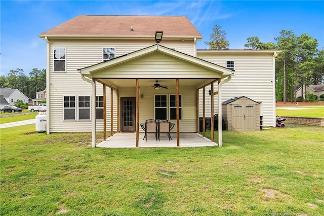 back of property featuring ceiling fan, a patio area, a shed, and a yard