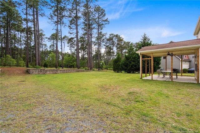 view of grassy yard featuring a patio and ceiling fan