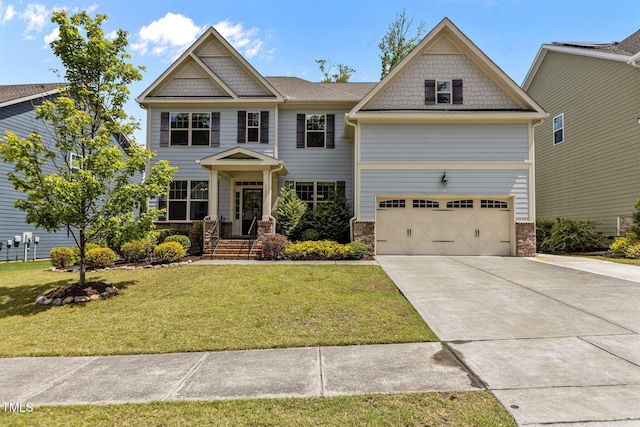 craftsman-style home with a garage, driveway, a front yard, and stone siding