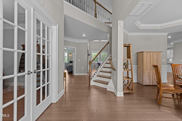 foyer entrance featuring french doors, stairway, ornamental molding, wood finished floors, and baseboards